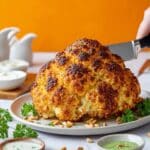 Whole Roasted Cauliflower with Whipped Feta, Herb Sauce, and Pine Nuts Recipe