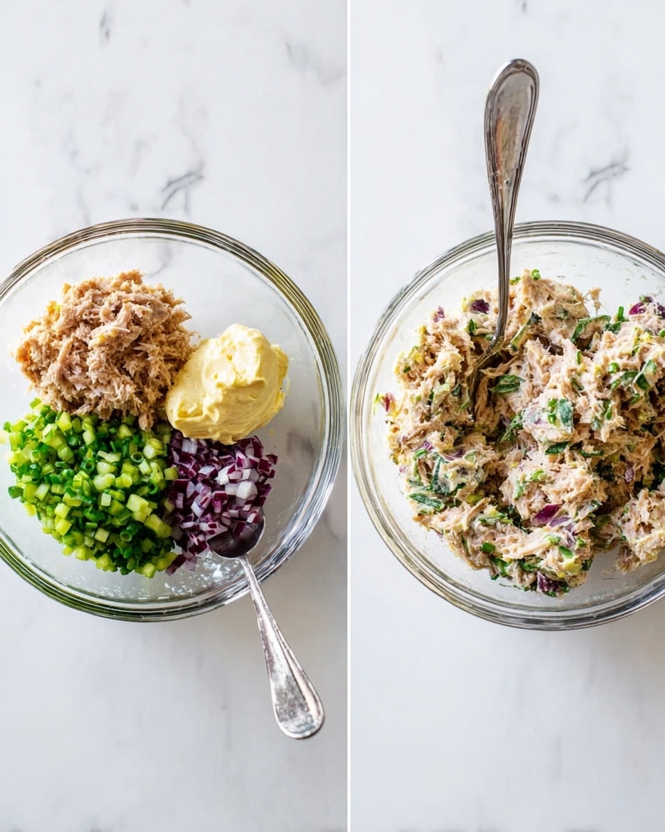 The image shows four avocado halves placed on a white plate over a white marbled surface. Each avocado half has a dark green, rough outer skin with bright light green smooth flesh inside. The hollow centers are filled with a creamy tuna salad mixture, which is off-white with small chunks and is mixed with pieces of green celery, purple onion, and green herbs. There are small green herbs placed on top of the salad for garnish. In front of the plate, a few fresh green parsley leaves lie on the white marbled surface. The photo taken with an iphone --ar 4:5 --v 7