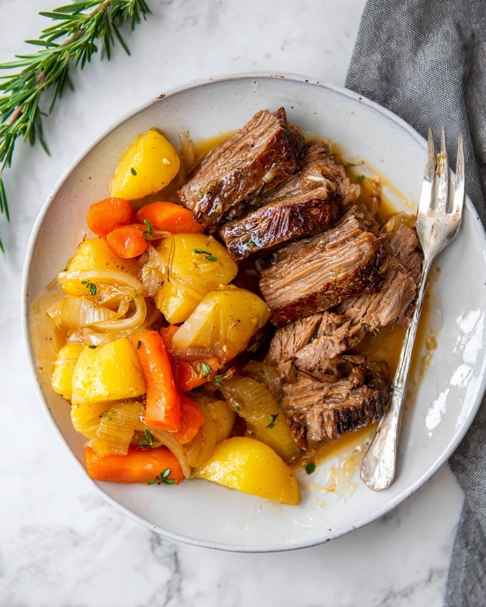 The dish shows a white plate with two main parts: on the right side there are several thick pieces of brown cooked meat with a slightly crispy outer layer and soft inside, layered loosely. On the left side, there are chunky pieces of yellow potatoes, bright orange carrot slices, and translucent cooked onions mixed together with a shiny golden sauce covering them. A silver fork rests on the right edge of the plate. The plate is placed on a white marbled surface with a small green rosemary sprig at the top left corner. Photo taken with an iphone --ar 4:5 --v 7